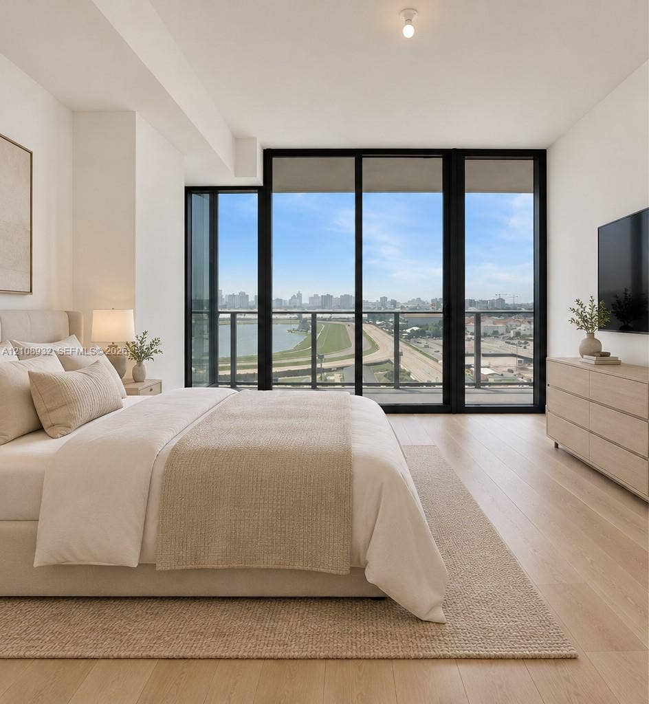 1170 E Hallandale Beach Boulevard, #1201, Hallandale Beach, FL 33009 Floor-to-ceiling black-frame windows, wood-finish flooring, and a private balcony with an exterior railing