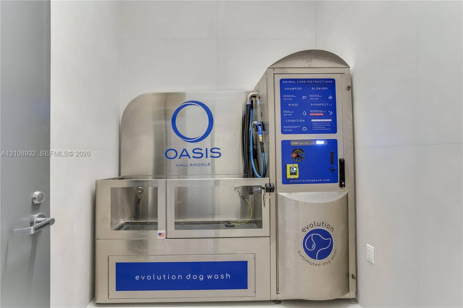 1170 E Hallandale Beach Boulevard, #1201, Hallandale Beach, FL 33009 Stainless steel automated pet washing station featuring a built-in spray nozzle, integrated control panel, and large-format wall tiling