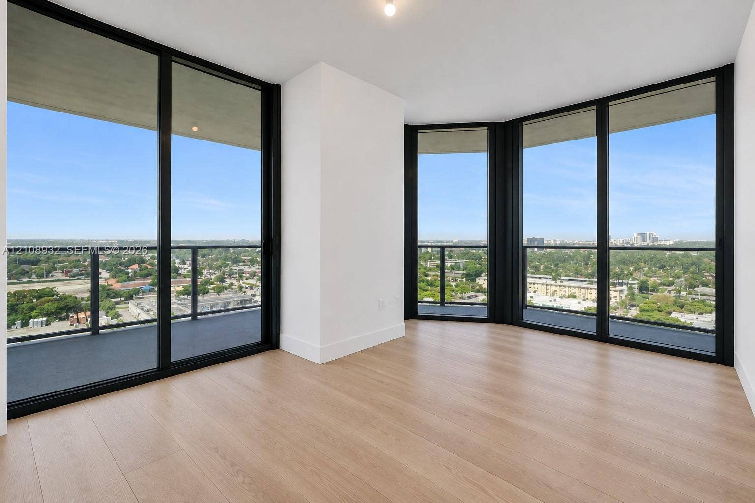 1170 E Hallandale Beach Boulevard, #1201, Hallandale Beach, FL 33009 Floor-to-ceiling windows with black metal frames, wood-finish flooring, and expansive wrap-around balcony access