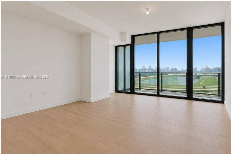 1170 E Hallandale Beach Boulevard, #1201, Hallandale Beach, FL 33009 Floor-to-ceiling windows, wood-finish flooring, and access to a balcony with metallic railing