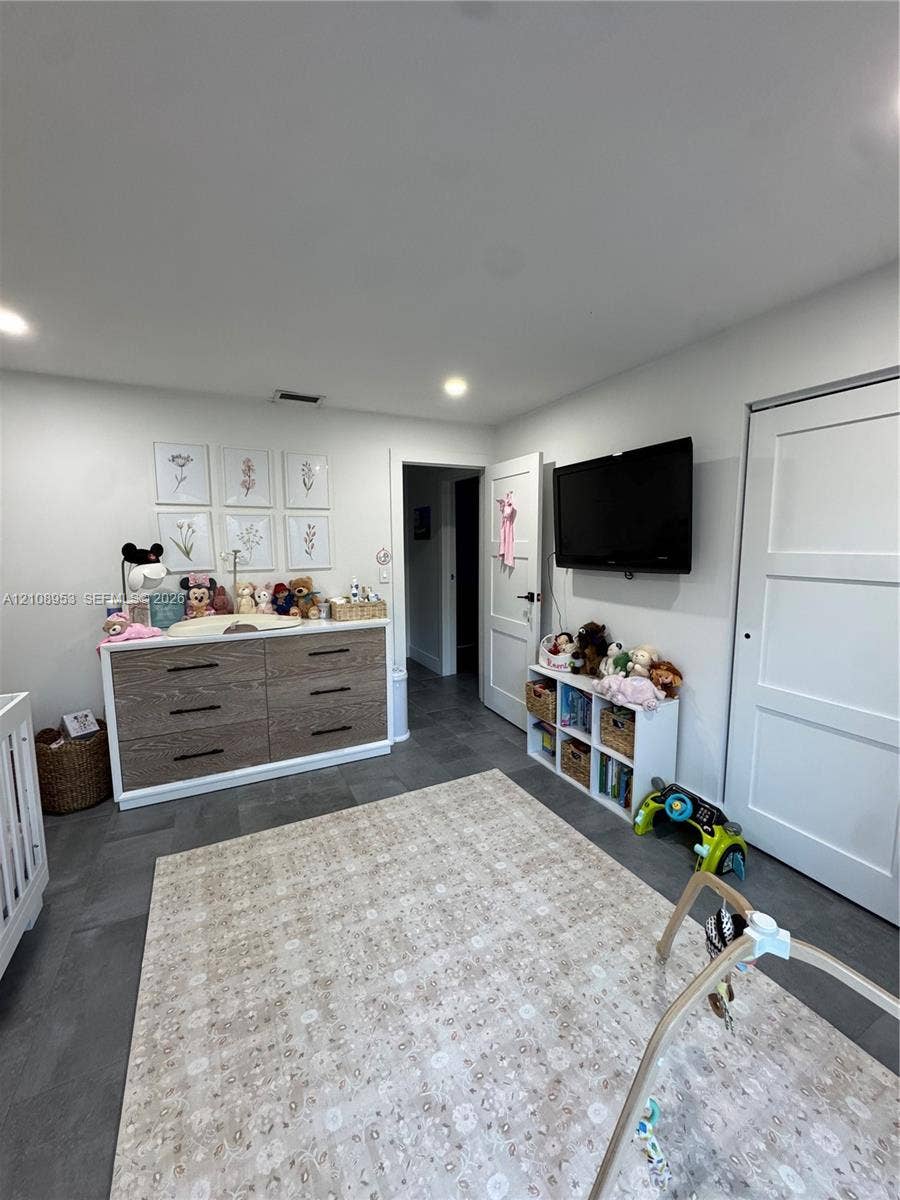 Neutral-toned interior featuring recessed lighting, large-format grey tile flooring, and solid-core paneled doors