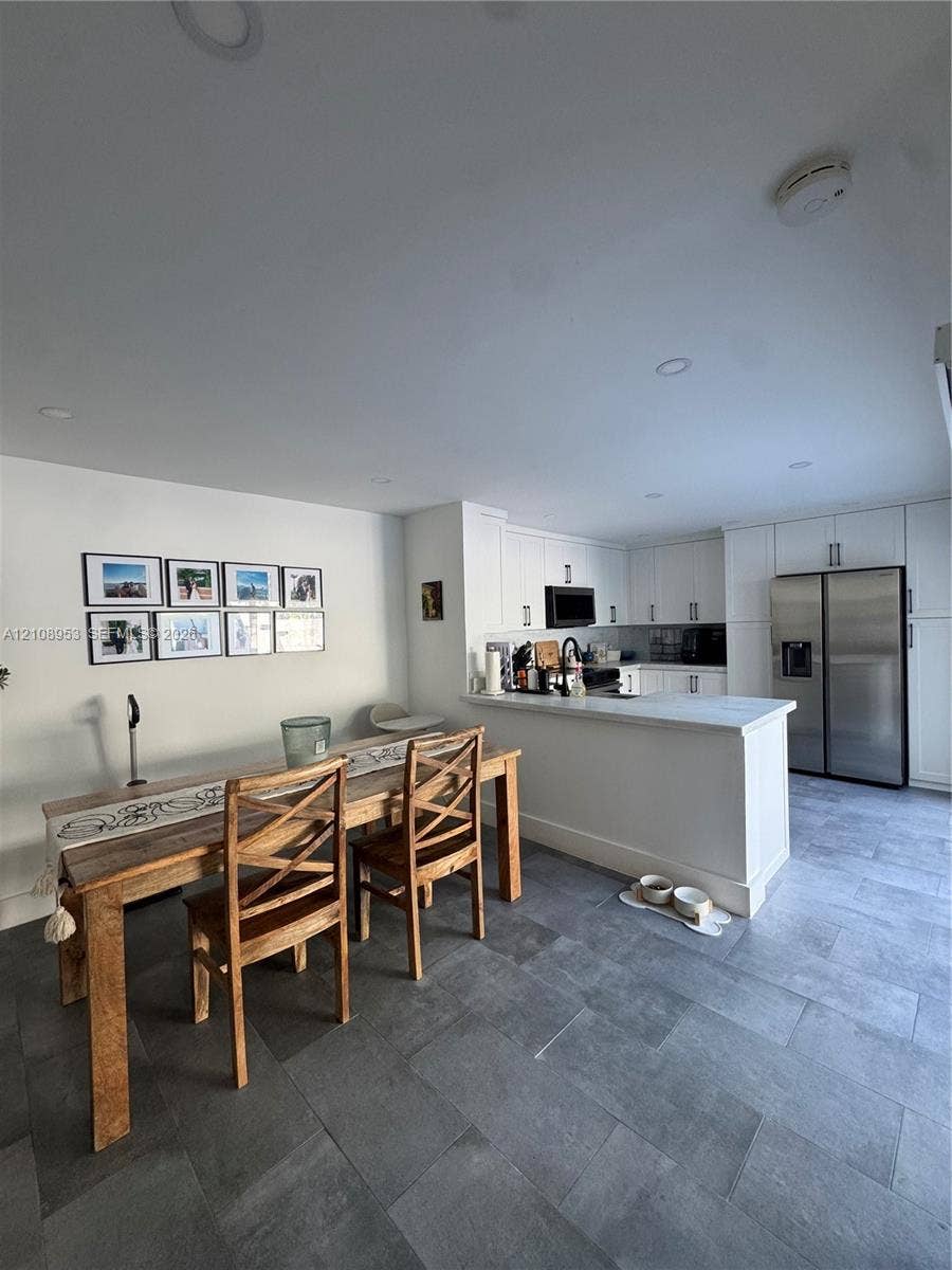 Kitchen featuring white shaker-style cabinetry, quartz countertops, a stainless steel side-by-side refrigerator, recessed lighting, and large-format tile flooring