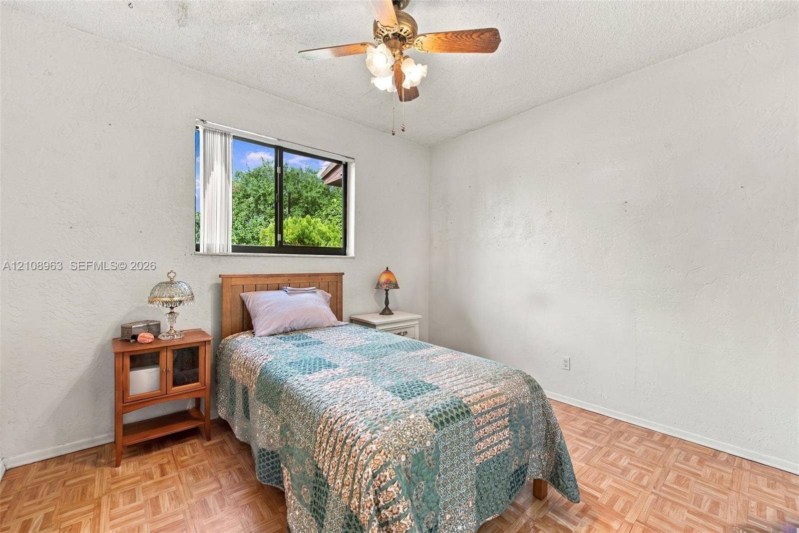 Parquet flooring, single-pane window, and ceiling-mounted light fixture with fan