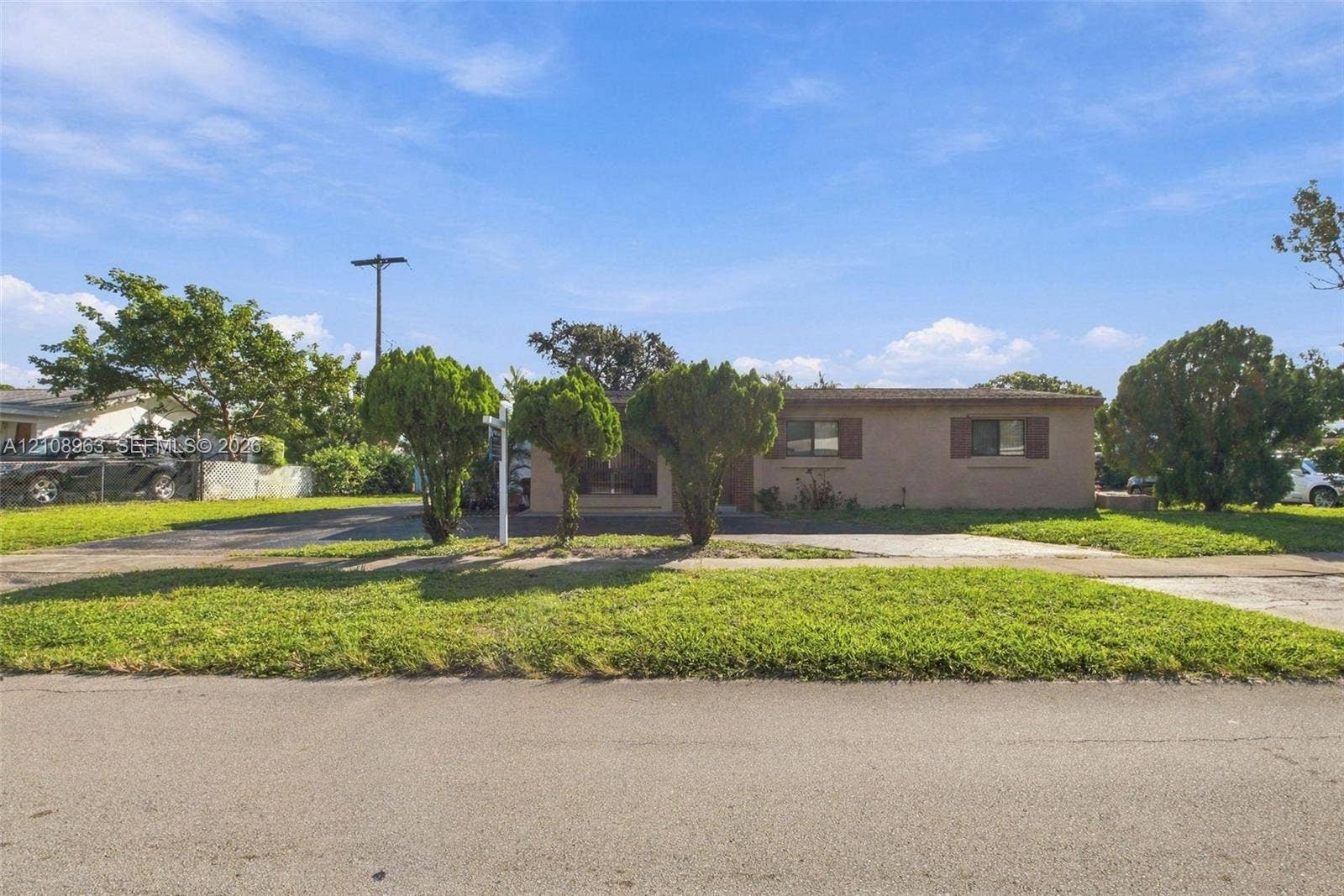 Single-story residence featuring a stucco exterior, horizontal rectangular windows, a covered front entry, and a concrete driveway