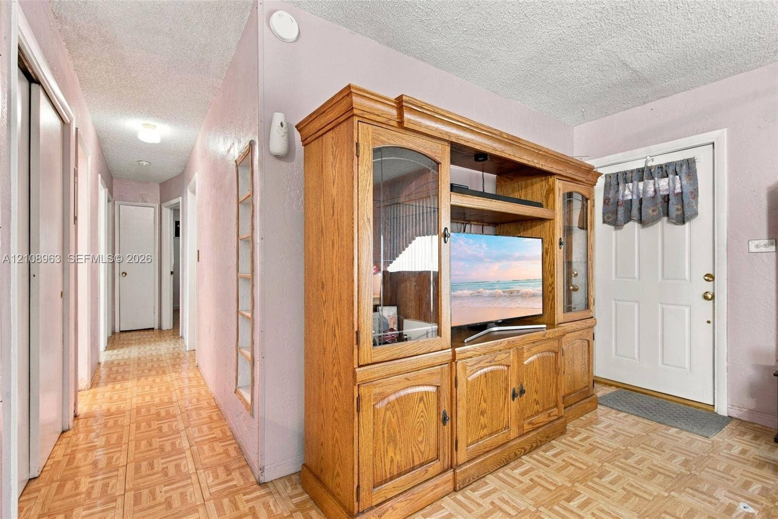 Parquet flooring throughout, white six-panel door with glass inset, and recessed ceiling lighting