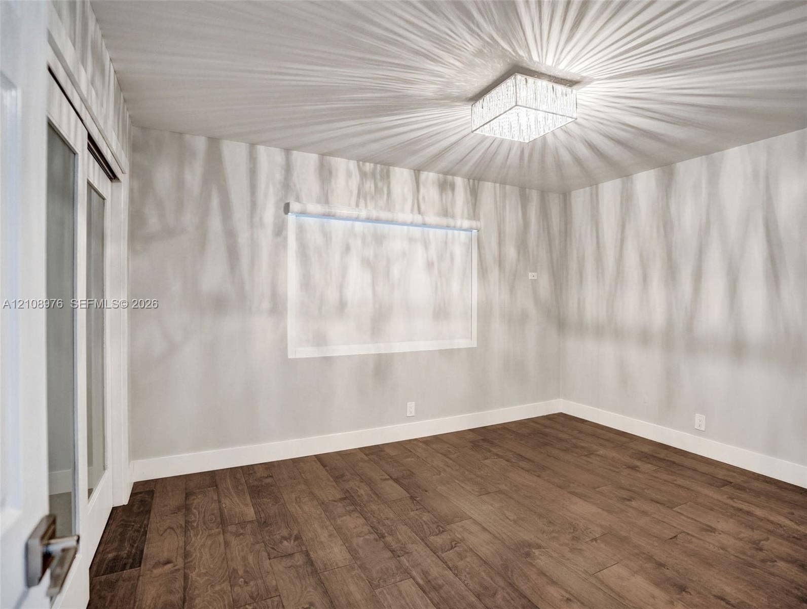 525 SW 12th Street, Fort Lauderdale, Fort Lauderdale, FL 33315 Room featuring wood-finish flooring, square crystal-accented flush mount ceiling light, and double doors with glass inserts