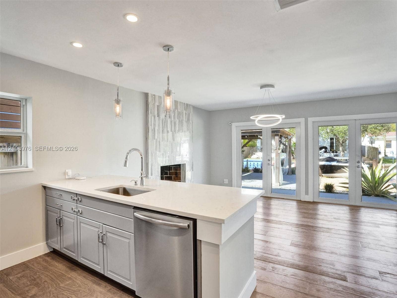 525 SW 12th Street, Fort Lauderdale, Fort Lauderdale, FL 33315 Kitchen island featuring light-toned cabinetry, a stone-finish countertop, stainless steel undermount sink, and recessed lighting