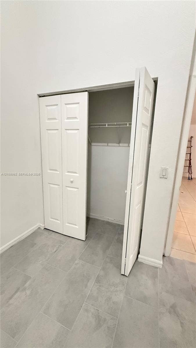 Bifold closet doors featuring white paneled detailing and a built-in wire shelving system