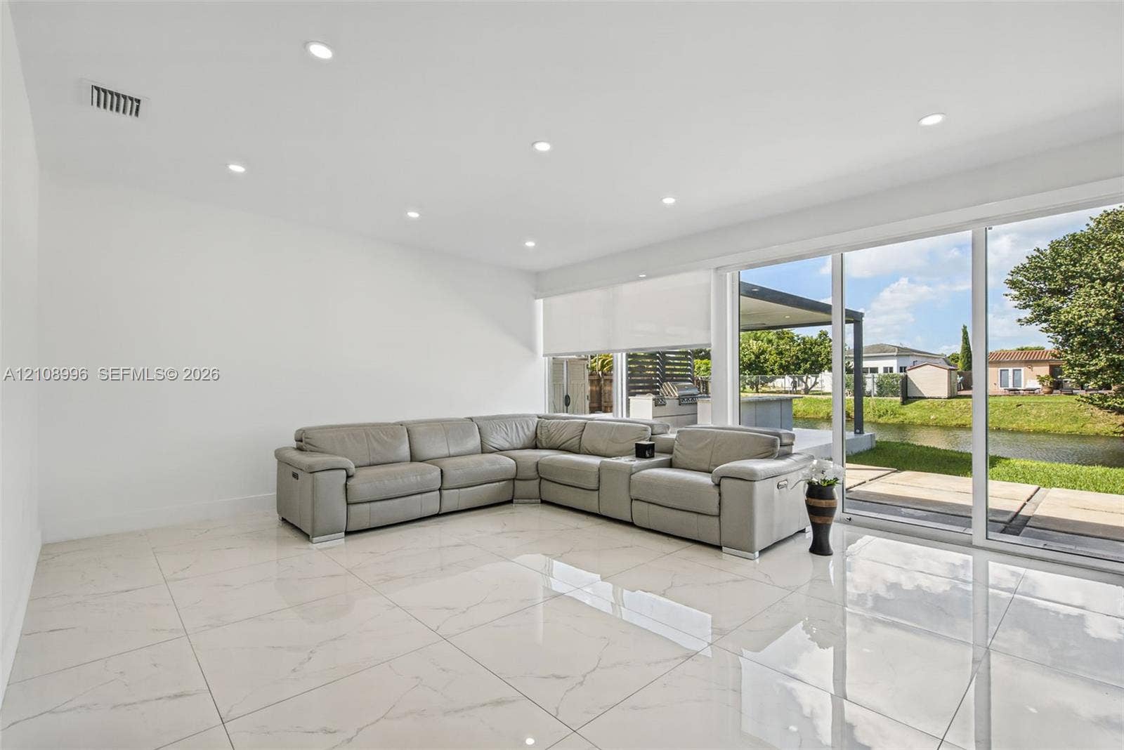 4252 SW 131st Avenue, Miami, FL 33175 Large-format tile flooring, recessed ceiling lighting, and expansive glass sliding doors