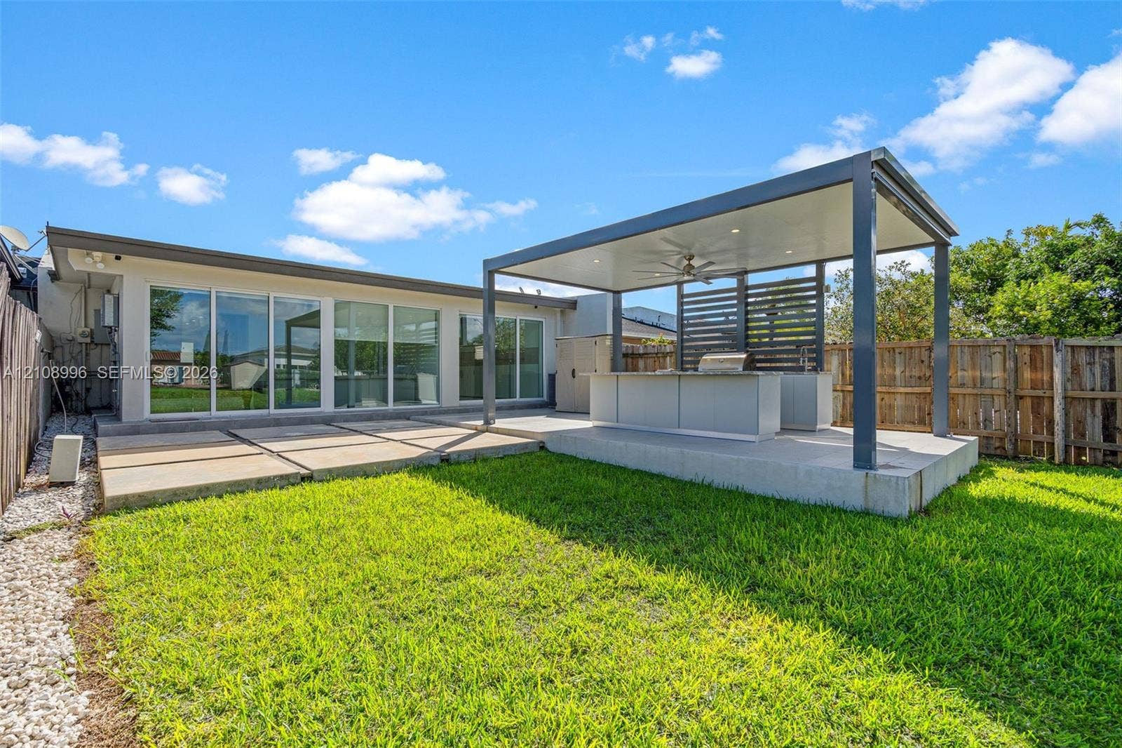 4252 SW 131st Avenue, Miami, FL 33175 Backyard featuring a covered patio with a built-in outdoor kitchen, recessed ceiling lighting, a ceiling fan, and large-format concrete pavers