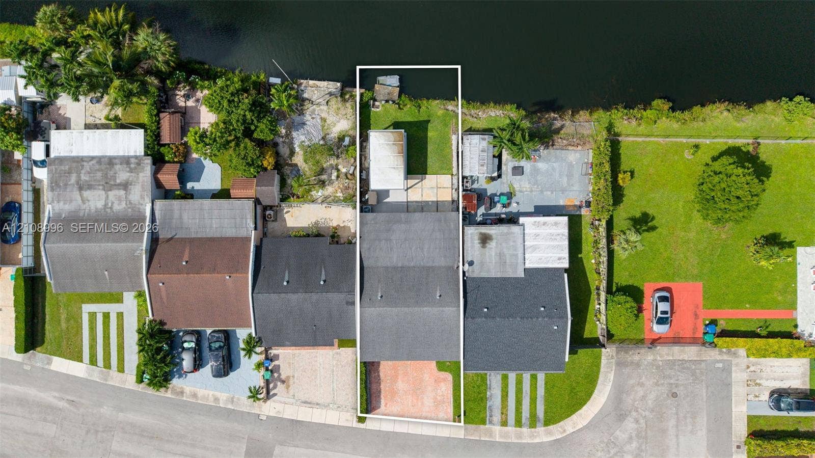 4252 SW 131st Avenue, Miami, FL 33175 Waterfront property featuring a canal-front parcel, paved driveway, concrete rear patio, and fenced lawn area