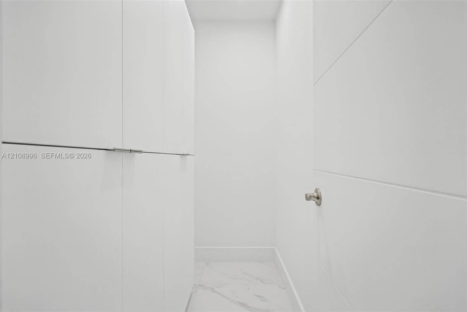 4252 SW 131st Avenue, Miami, FL 33175 Built-in floor-to-ceiling cabinetry featuring clean-lined, white panel doors with minimalist hardware and white stone-finish tile flooring