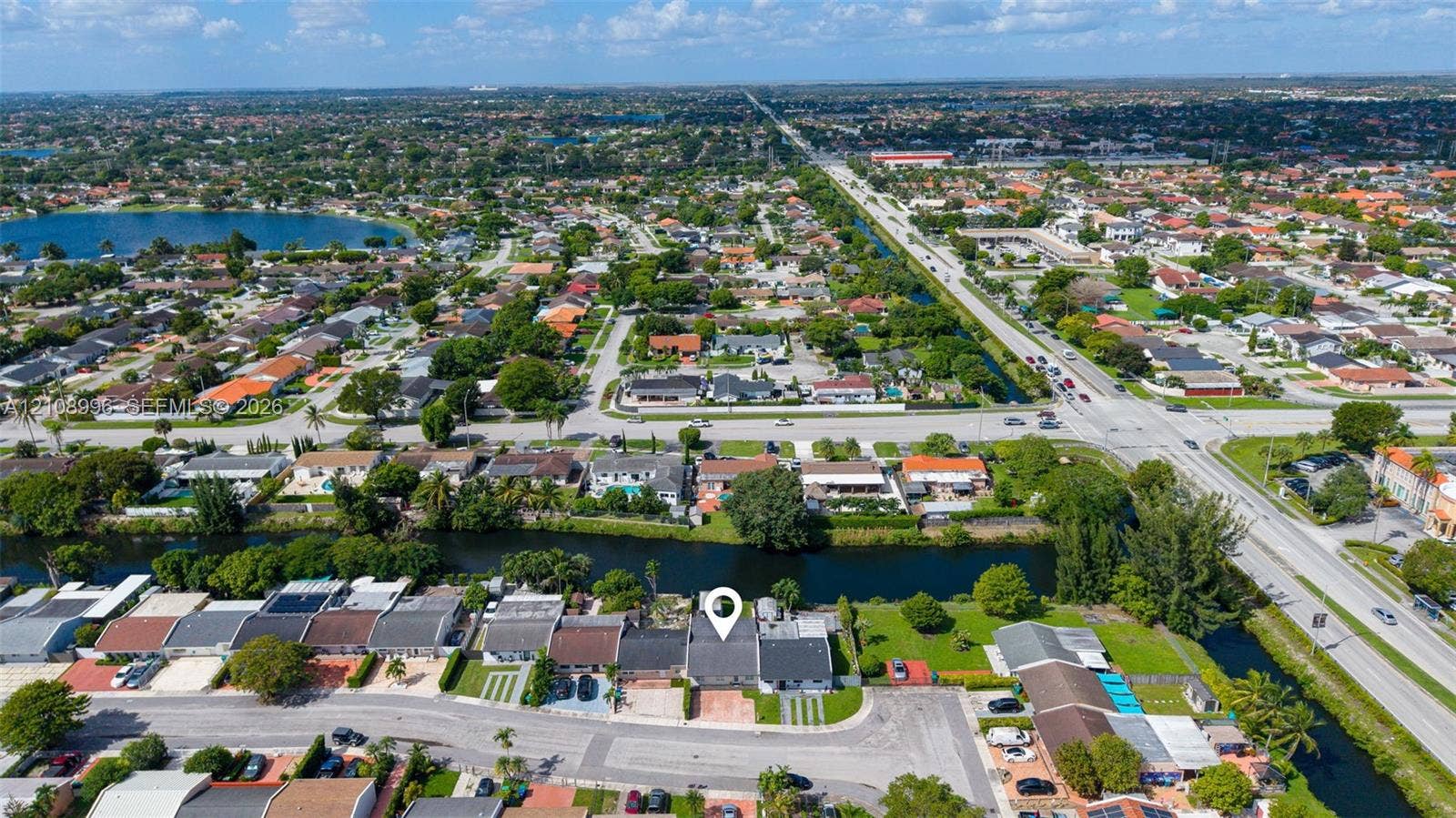 4252 SW 131st Avenue, Miami, FL 33175 Aerial perspective of a single-story residence featuring a concrete tile roof, paved driveway, and canal-front positioning