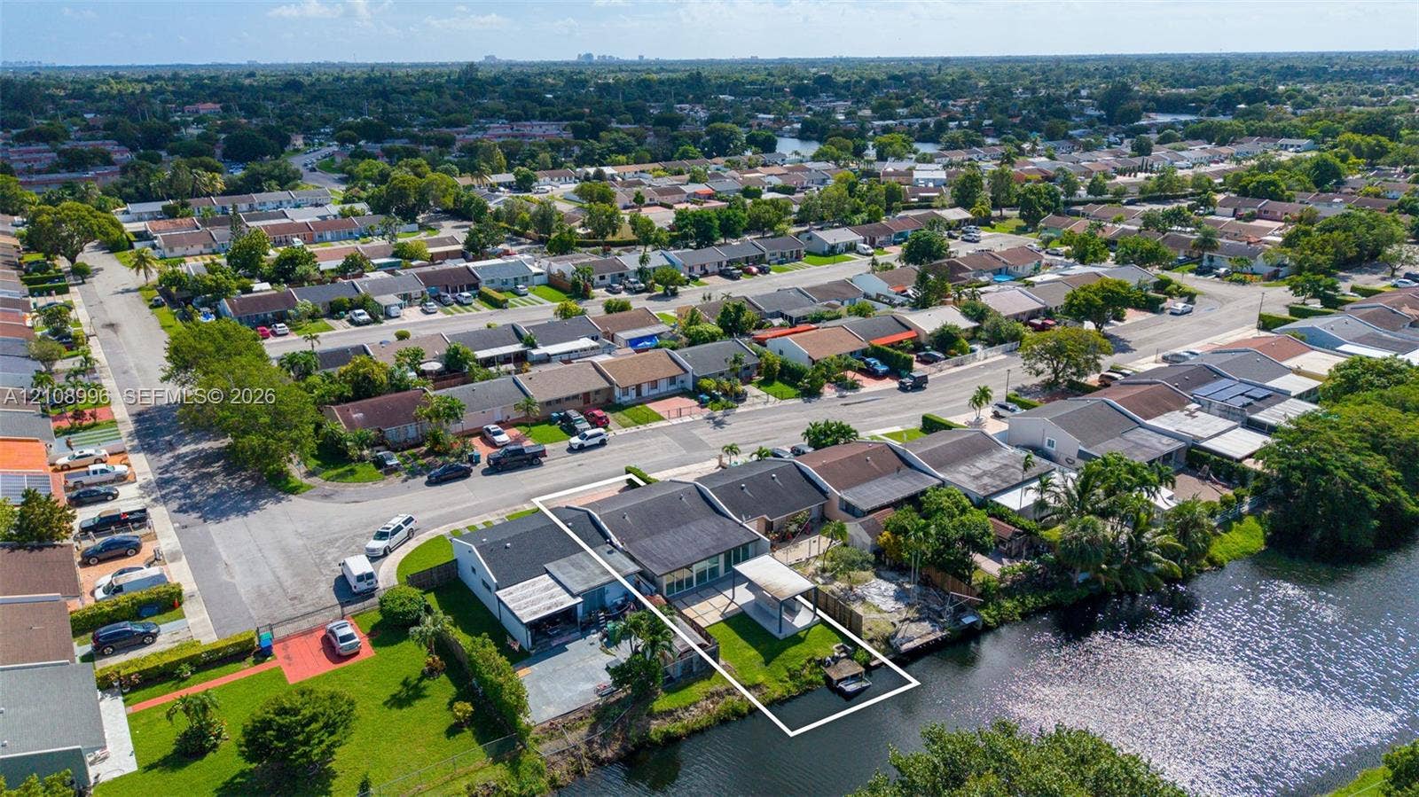 4252 SW 131st Avenue, Miami, FL 33175 Waterfront property featuring a canal-side bulkhead, concrete patio, lawn area, and a metal-frame pergola