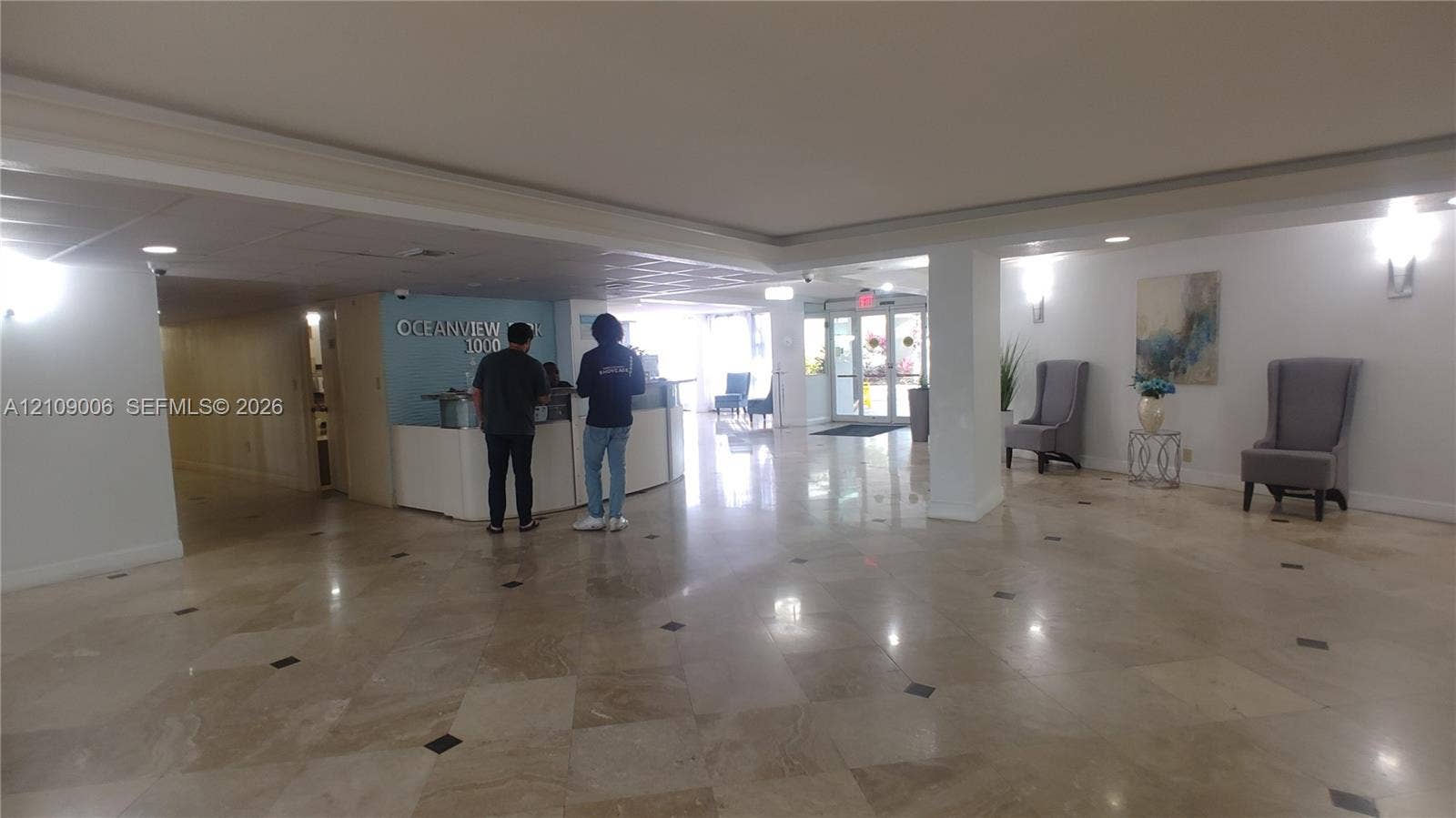 Lobby featuring polished stone flooring with decorative inlays, recessed lighting, and a built-in reception desk