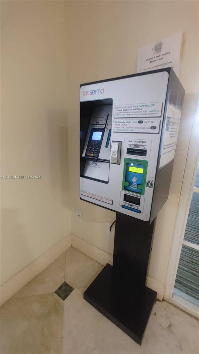 Wall-mounted digital payment kiosk featuring a bill acceptor and integrated card loading system