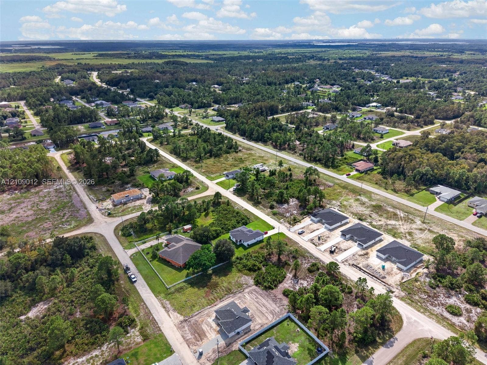 846 Burns Avenue S, Lehigh Acres, Lehigh Acres, FL 33974 Aerial perspective of residential area featuring paved streets, established lot configurations, and surrounding woodland expanses