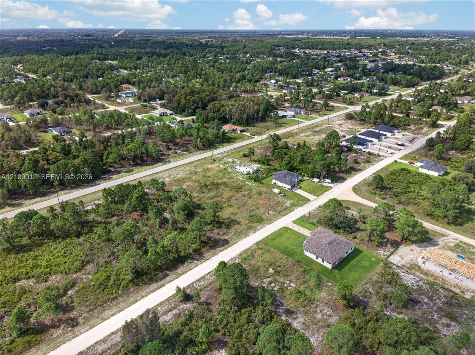 846 Burns Avenue S, Lehigh Acres, Lehigh Acres, FL 33974 Aerial perspective of a multi-acre parcel featuring native vegetation, established trees, and paved street access