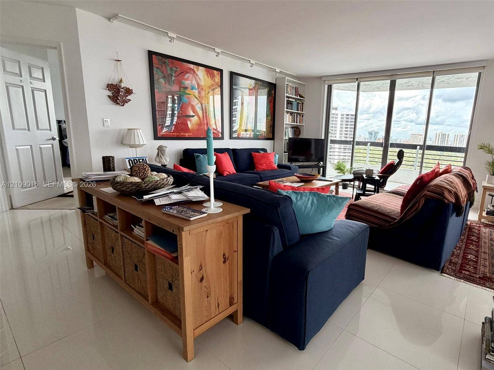 3530 Mystic Pointe Drive, #1709, Aventura, FL 33180 Living space featuring large-format tile flooring, floor-to-ceiling glass doors, integrated track lighting, and built-in shelving