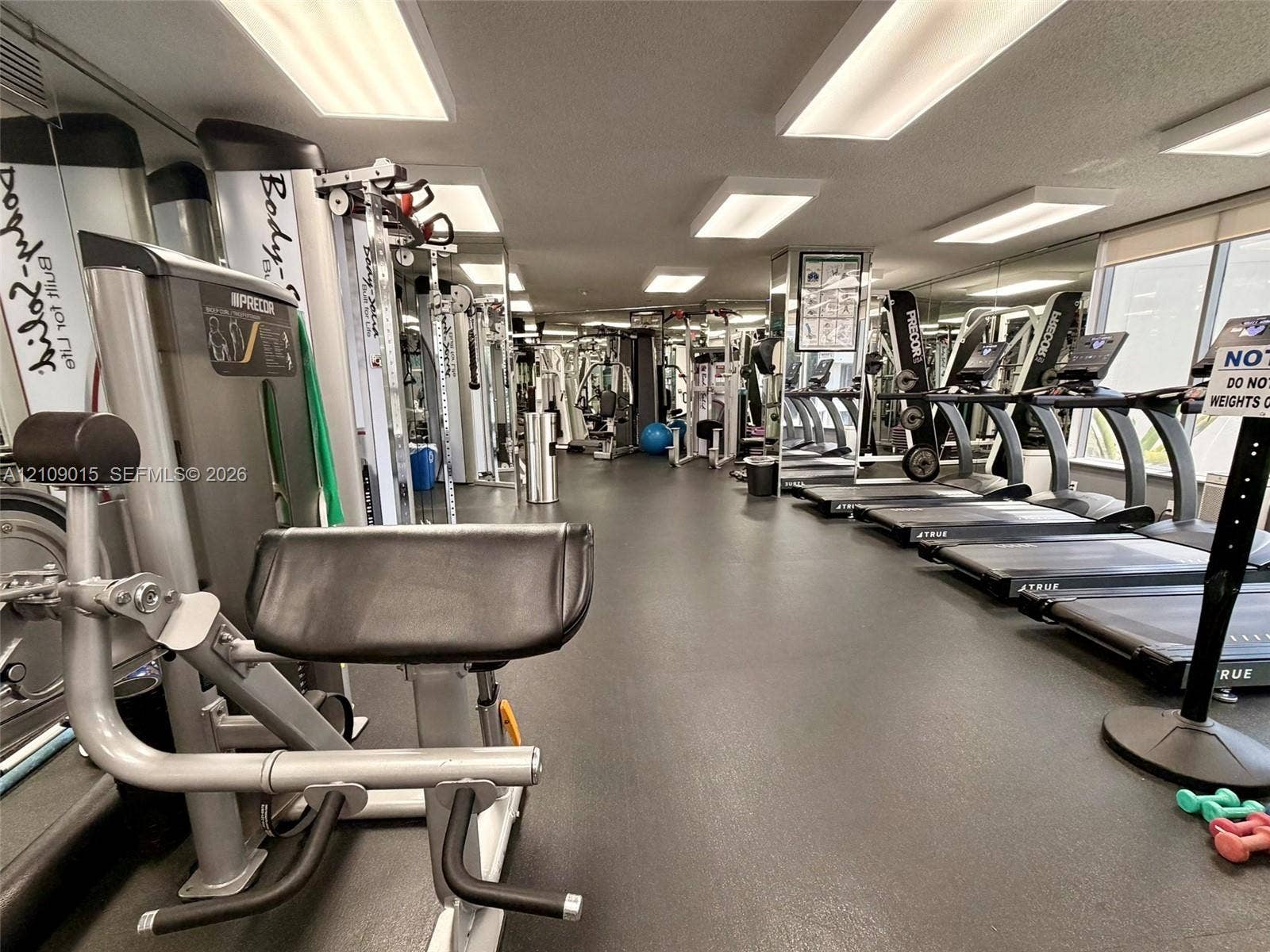 3530 Mystic Pointe Drive, #1709, Aventura, FL 33180 Fitness center featuring rubber flooring, recessed ceiling lighting, and wall-to-wall mirrored surfaces