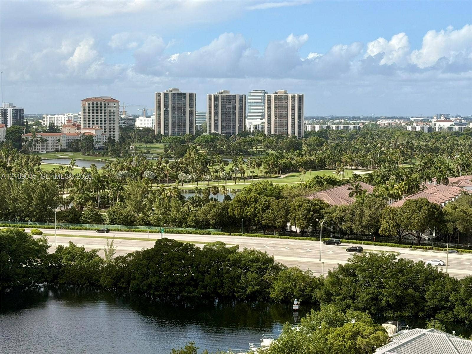 3530 Mystic Pointe Drive, #1709, Aventura, FL 33180 Panoramic landscape featuring golf course grounds, mature tree canopy, natural water features, and high-rise skyline