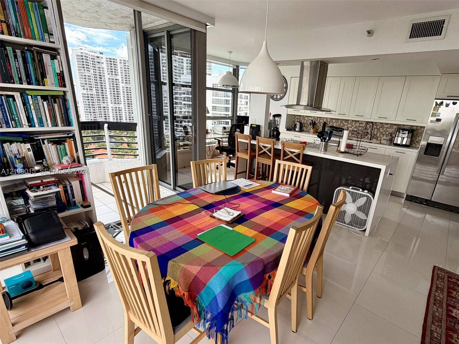 3530 Mystic Pointe Drive, #1709, Aventura, FL 33180 Open-concept kitchen featuring crisp white cabinetry, a large kitchen island with a stone-finish countertop, stainless steel appliances, and tile flooring