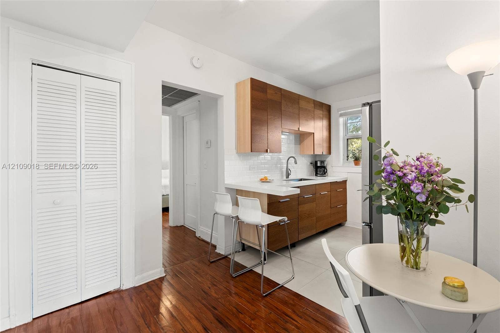 536 14th Street, #305, Miami Beach, Miami Beach, FL 33139 Kitchen featuring wood-finish cabinetry, white solid-surface countertops, a subway tile backsplash, and wood-finish flooring