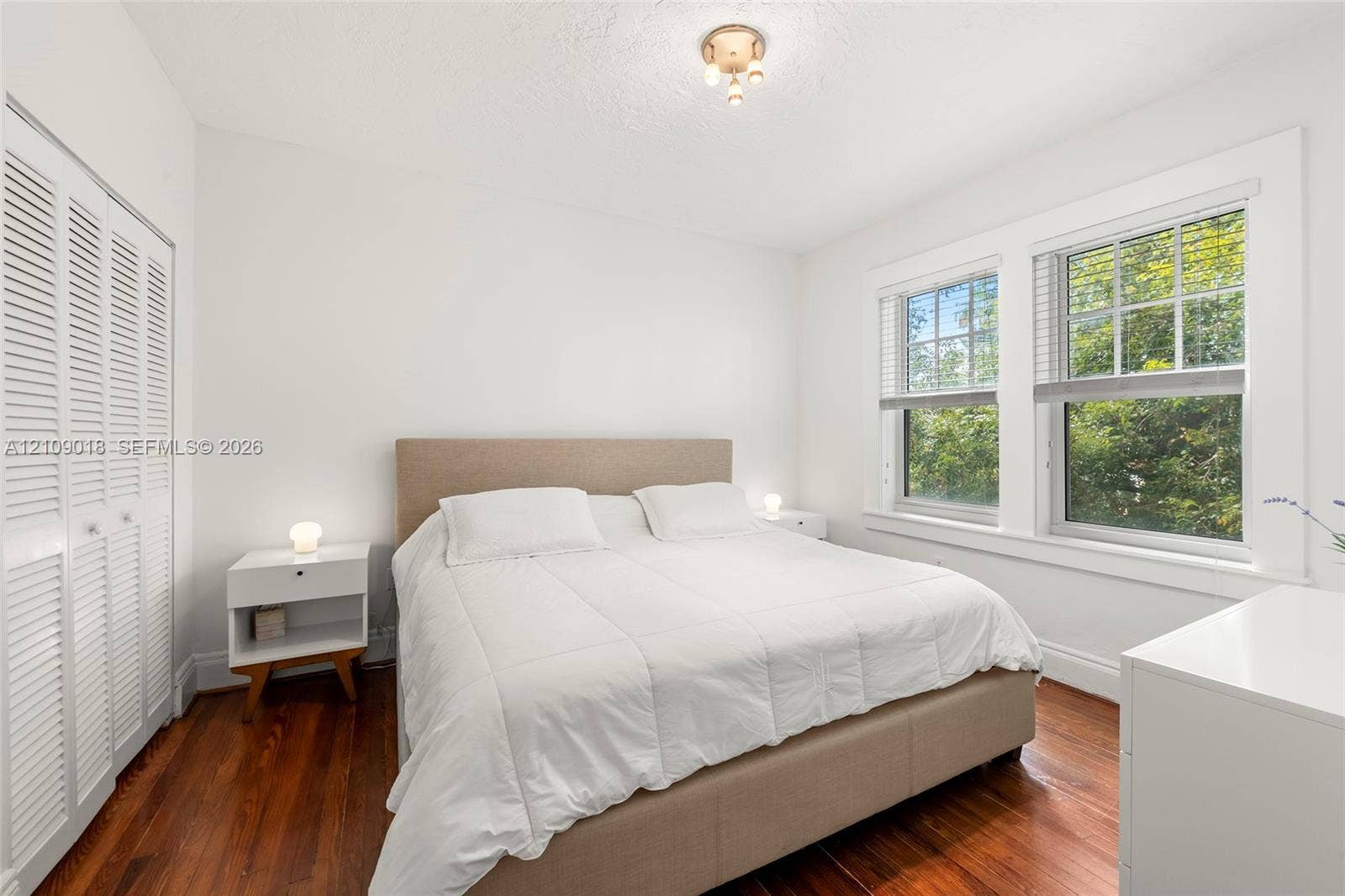 536 14th Street, #305, Miami Beach, Miami Beach, FL 33139 Room with wood-finish flooring, dual windows with grid-patterned glass, and white louvered closet doors