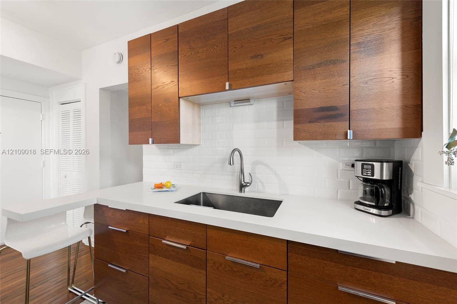 536 14th Street, #305, Miami Beach, Miami Beach, FL 33139 Kitchen featuring natural wood-finish cabinetry, solid surface countertops, white subway tile backsplash, stainless steel undermount sink, and a gooseneck faucet