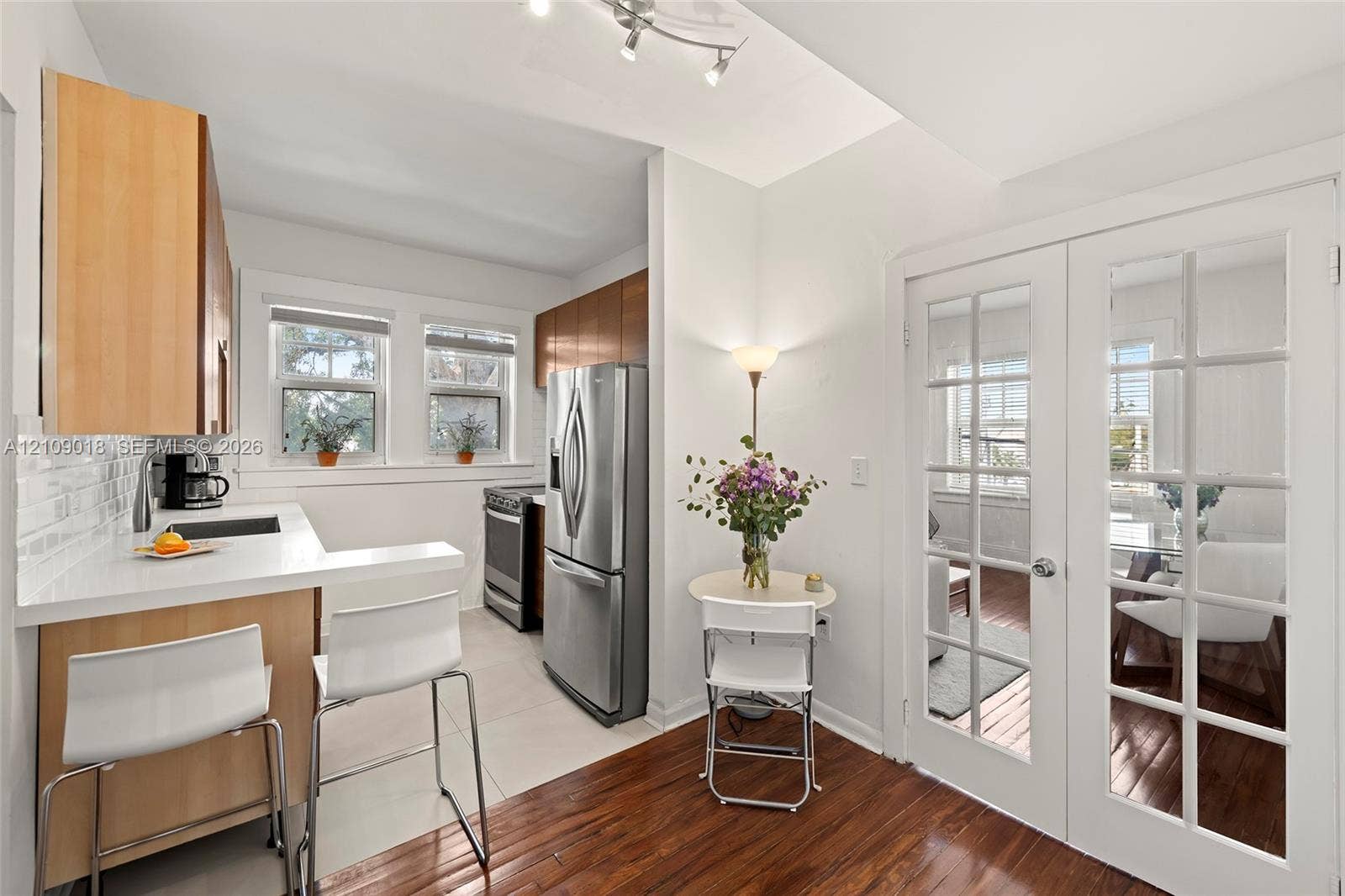 536 14th Street, #305, Miami Beach, Miami Beach, FL 33139 Kitchen featuring light wood-finish cabinetry, solid-surface countertops, subway tile backsplash, stainless steel appliances, and French doors with glass panes