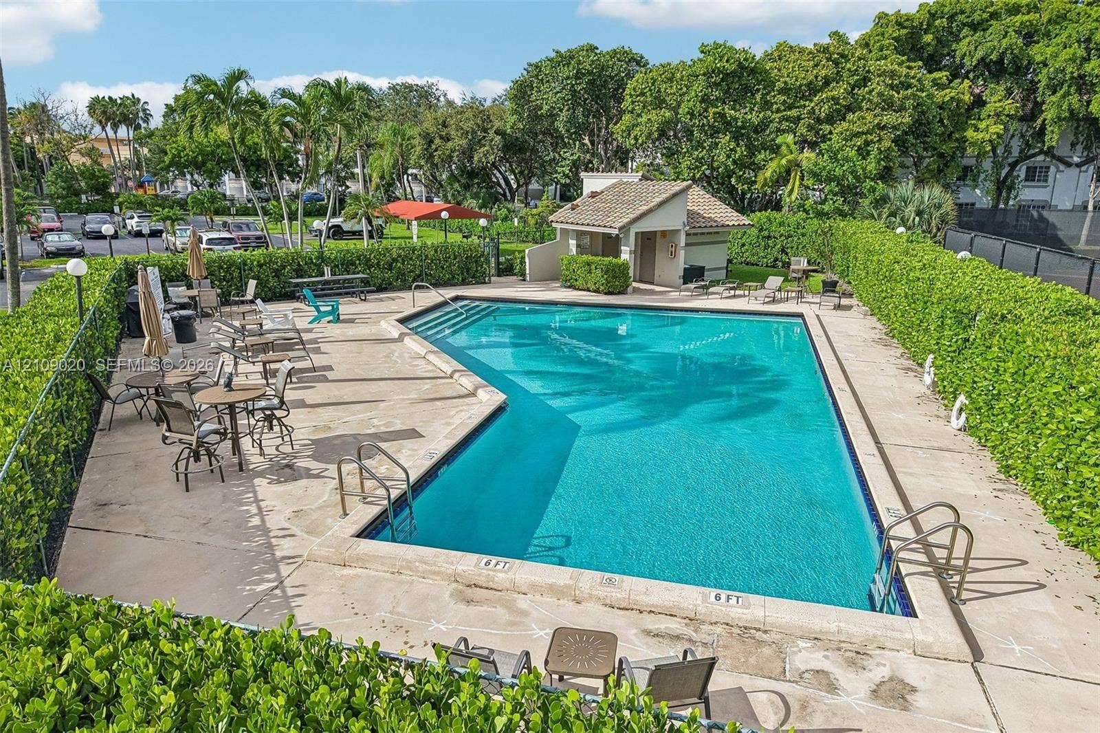 701 NW 19th Street, #300, Fort Lauderdale, FL 33311 In-ground swimming pool with a concrete deck, enclosed by manicured privacy hedges and accompanied by a dedicated pool house