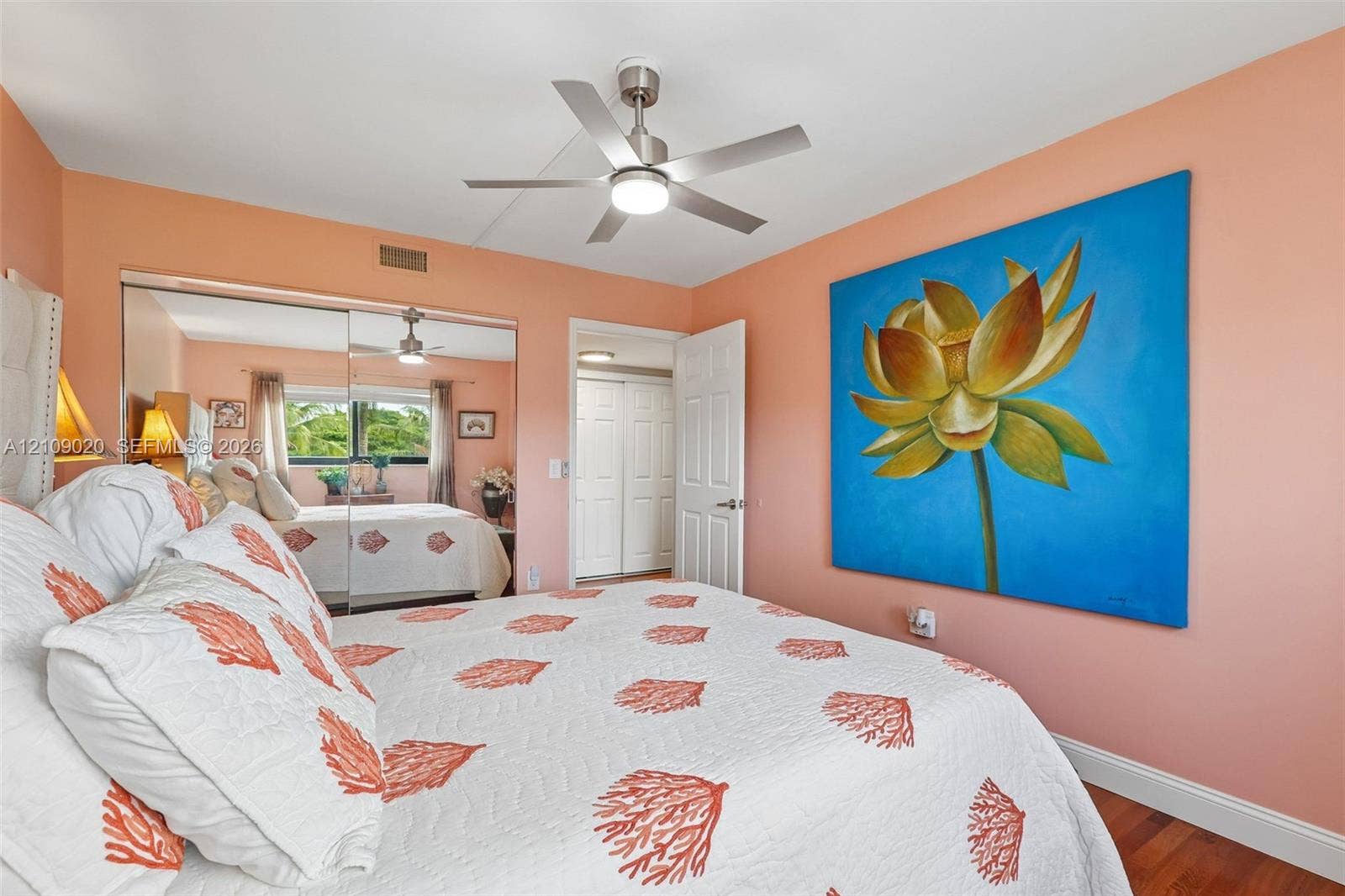 701 NW 19th Street, #300, Fort Lauderdale, FL 33311 Bedroom featuring wood-finish flooring, a brushed nickel ceiling fan with integrated lighting, and mirrored closet doors
