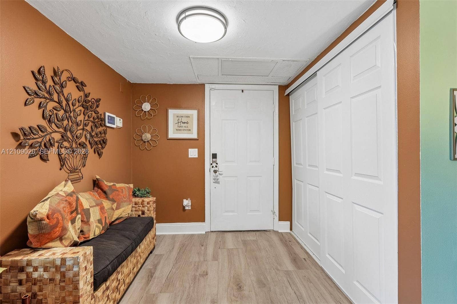 701 NW 19th Street, #300, Fort Lauderdale, FL 33311 Entryway featuring light-toned wood-finish flooring, white six-panel door, and a sliding white closet door with a six-panel design