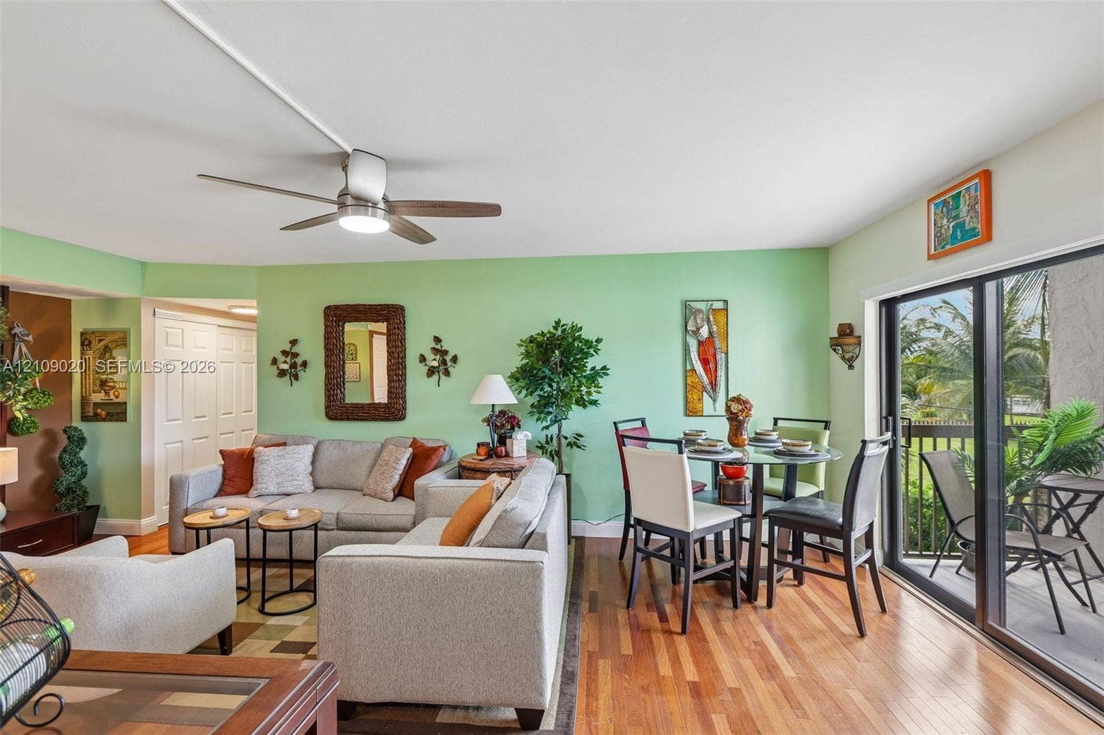 701 NW 19th Street, #300, Fort Lauderdale, FL 33311 Open-concept interior featuring wood-finish flooring, a ceiling fan with integrated lighting, and sliding glass doors providing access to the exterior