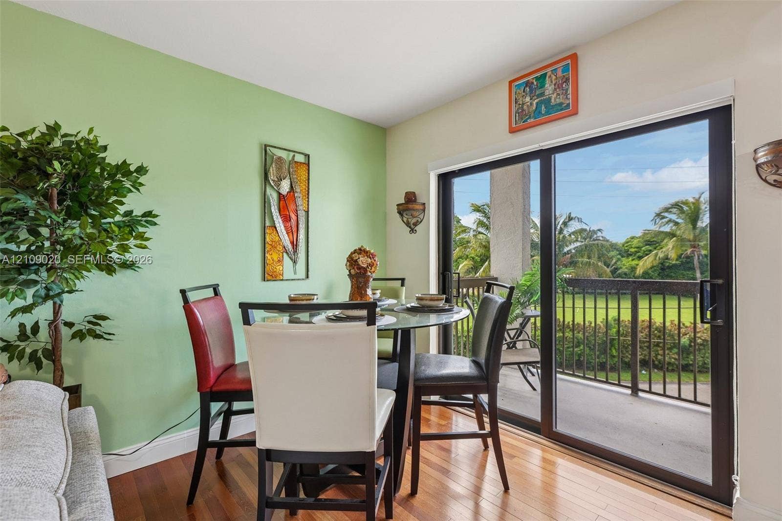 701 NW 19th Street, #300, Fort Lauderdale, FL 33311 Wood-finish flooring, sliding glass door, metal balcony railing, and wall-mounted light fixtures