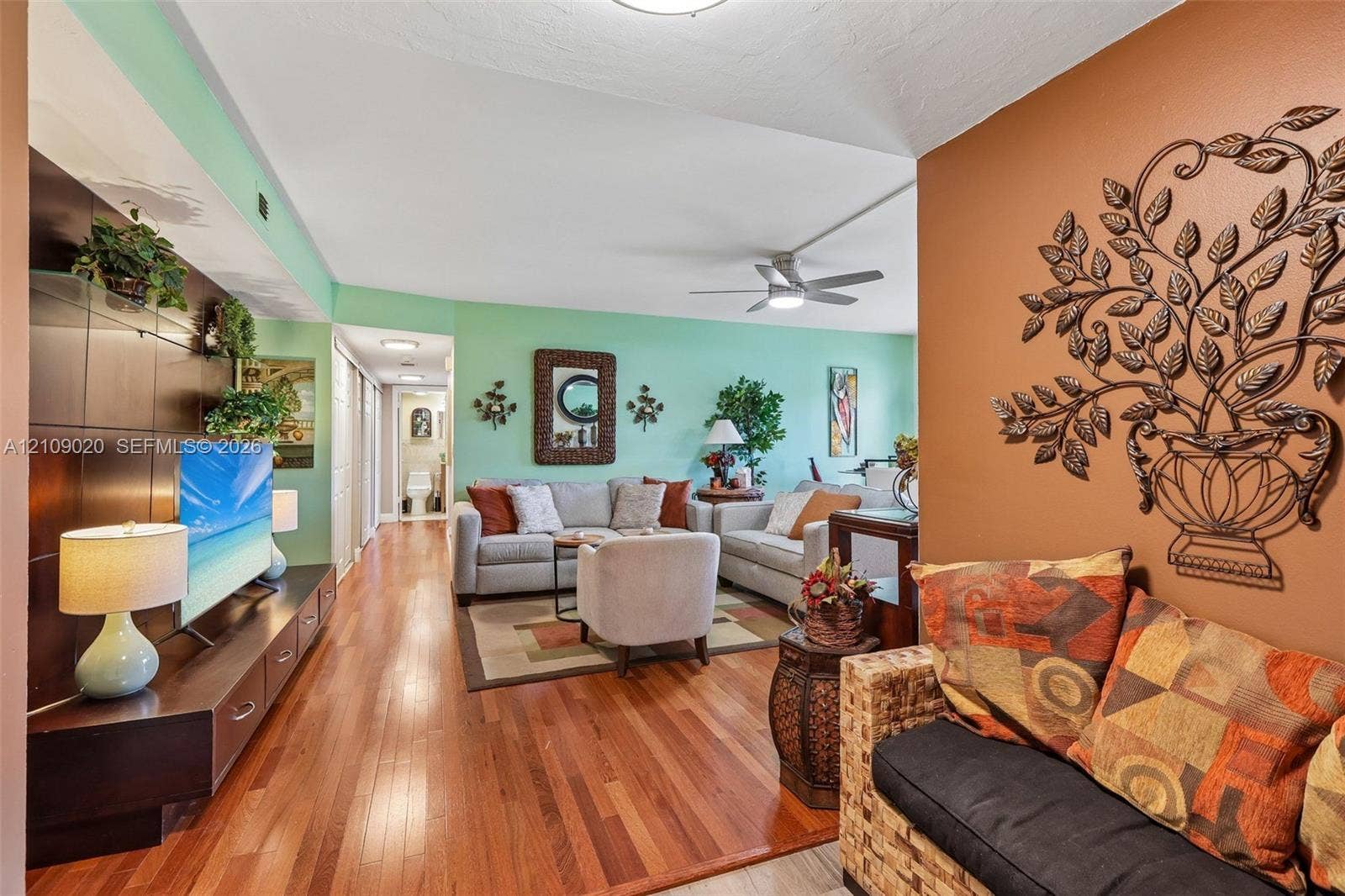 701 NW 19th Street, #300, Fort Lauderdale, FL 33311 Wood-finish flooring, built-in dark wood media cabinetry, and a ceiling fan