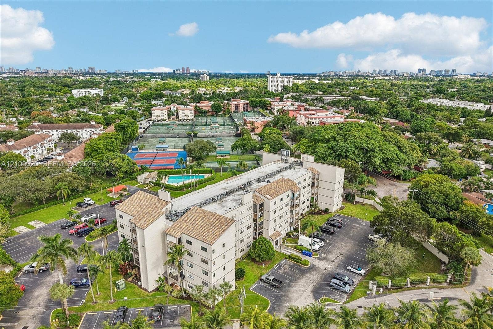 701 NW 19th Street, #300, Fort Lauderdale, FL 33311 Multi-story residential building featuring shingled rooflines, exterior parking areas, and mature landscaping