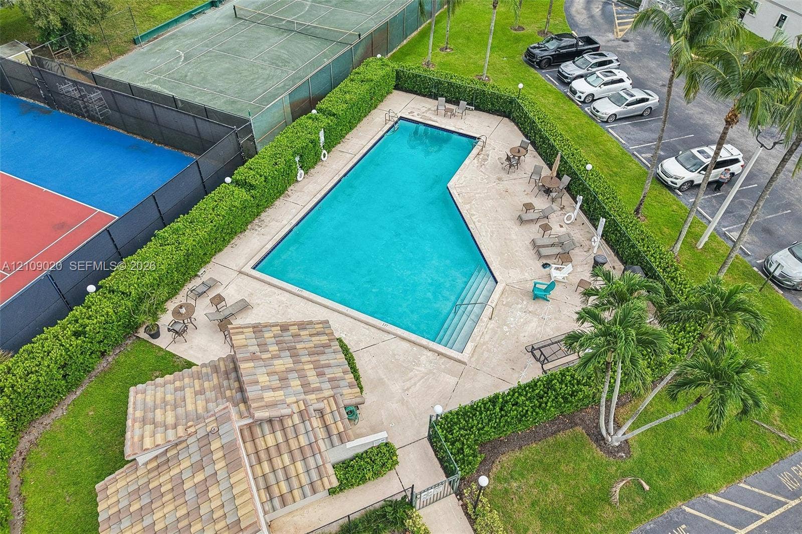 701 NW 19th Street, #300, Fort Lauderdale, FL 33311 Swimming pool with integrated stairs, tennis court, tiled pavilion structure, paved deck, and perimeter landscaping