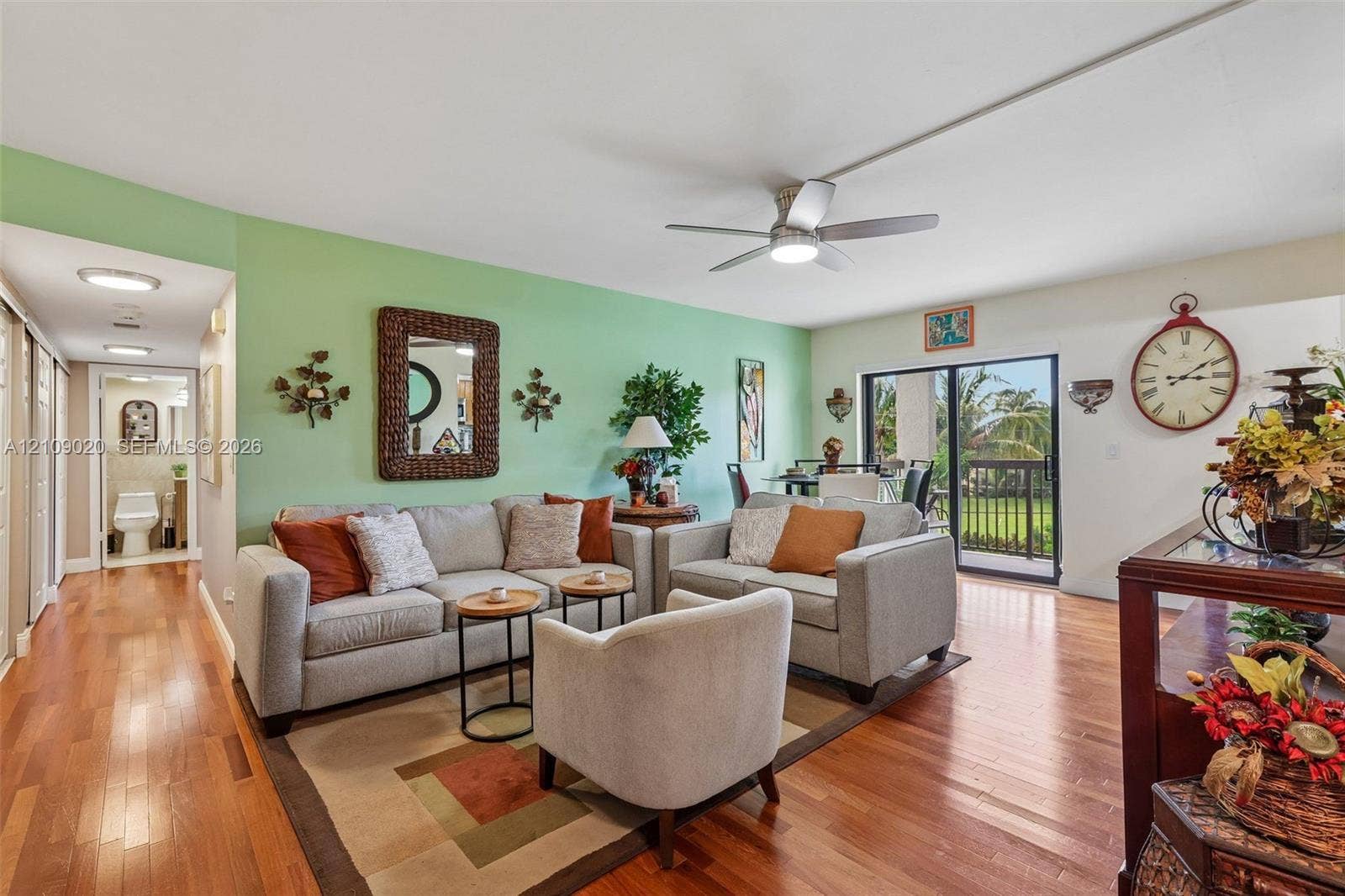 701 NW 19th Street, #300, Fort Lauderdale, FL 33311 Living area featuring wood-finish flooring, a ceiling fan with integrated lighting, and sliding glass doors