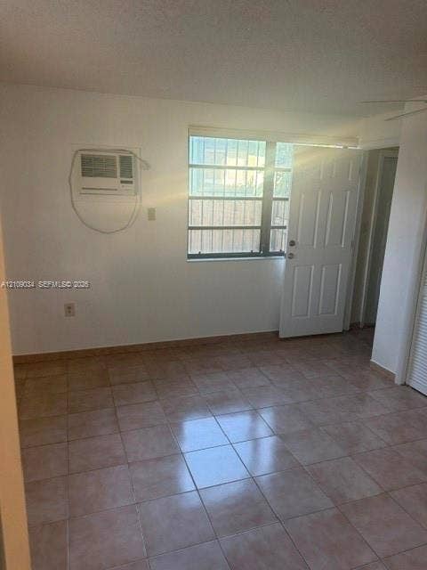 Interior room featuring neutral ceramic tile flooring, a multi-panel exterior door, and a multi-pane window with security bars