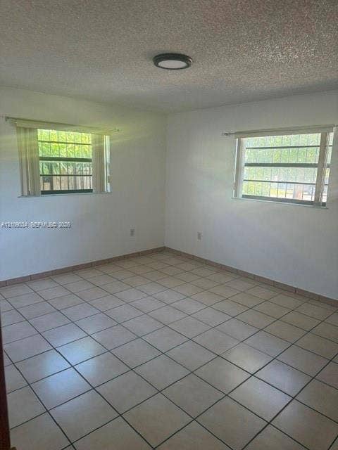 Neutral-toned tile flooring, dual windows with exterior security bars, and a flush-mount ceiling light fixture
