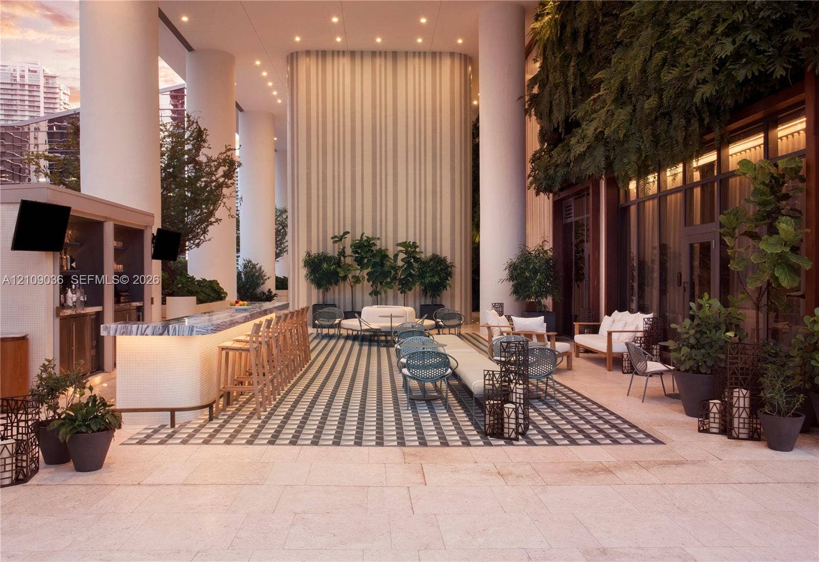 Covered outdoor lounge featuring structural columns, a built-in stone-top bar, recessed ceiling lighting, and tile flooring