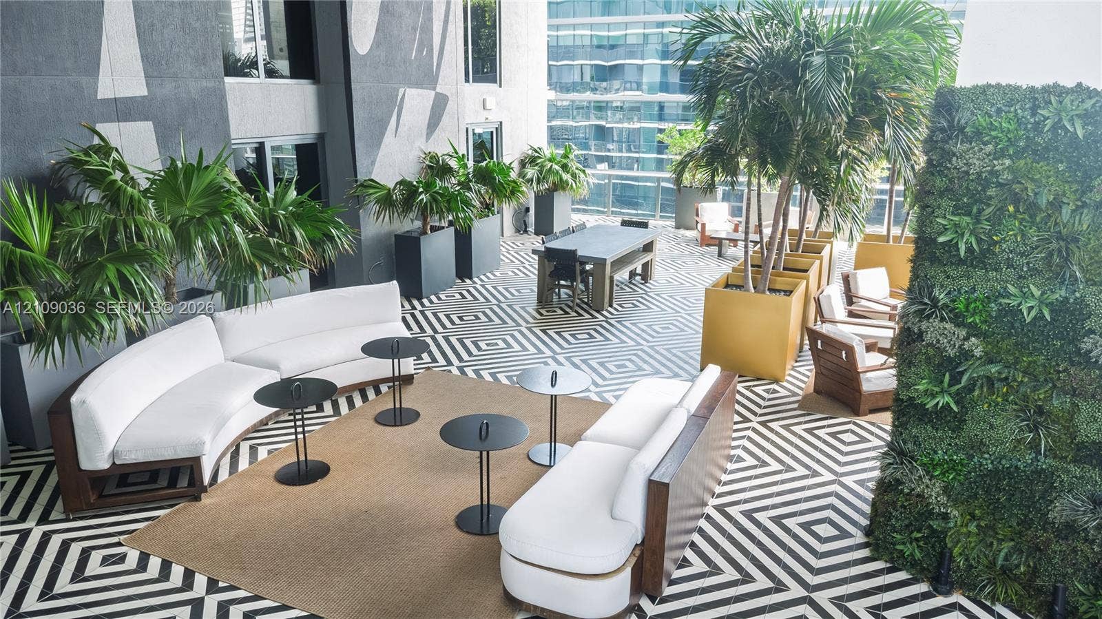 Outdoor terrace featuring a geometric tile floor, vertical living wall, and integrated built-in planters