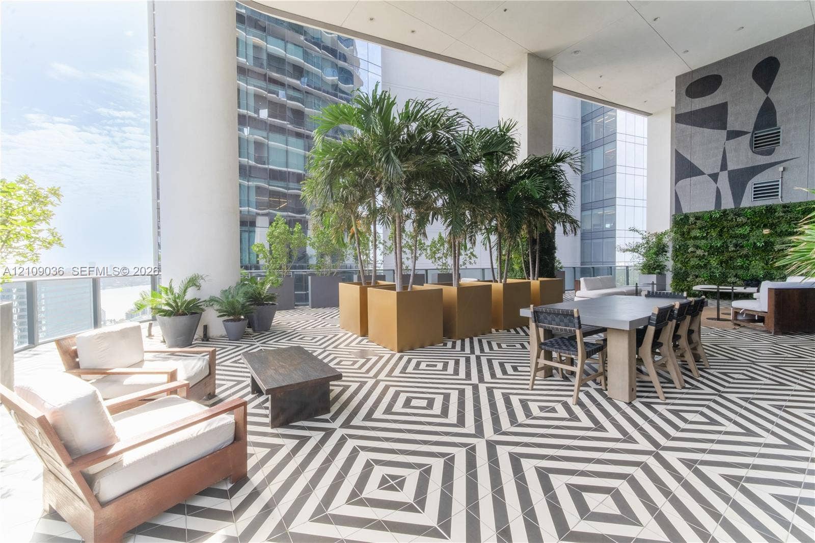 Covered outdoor terrace featuring geometric patterned floor tiling, integrated vertical greenery, and built-in structural columns