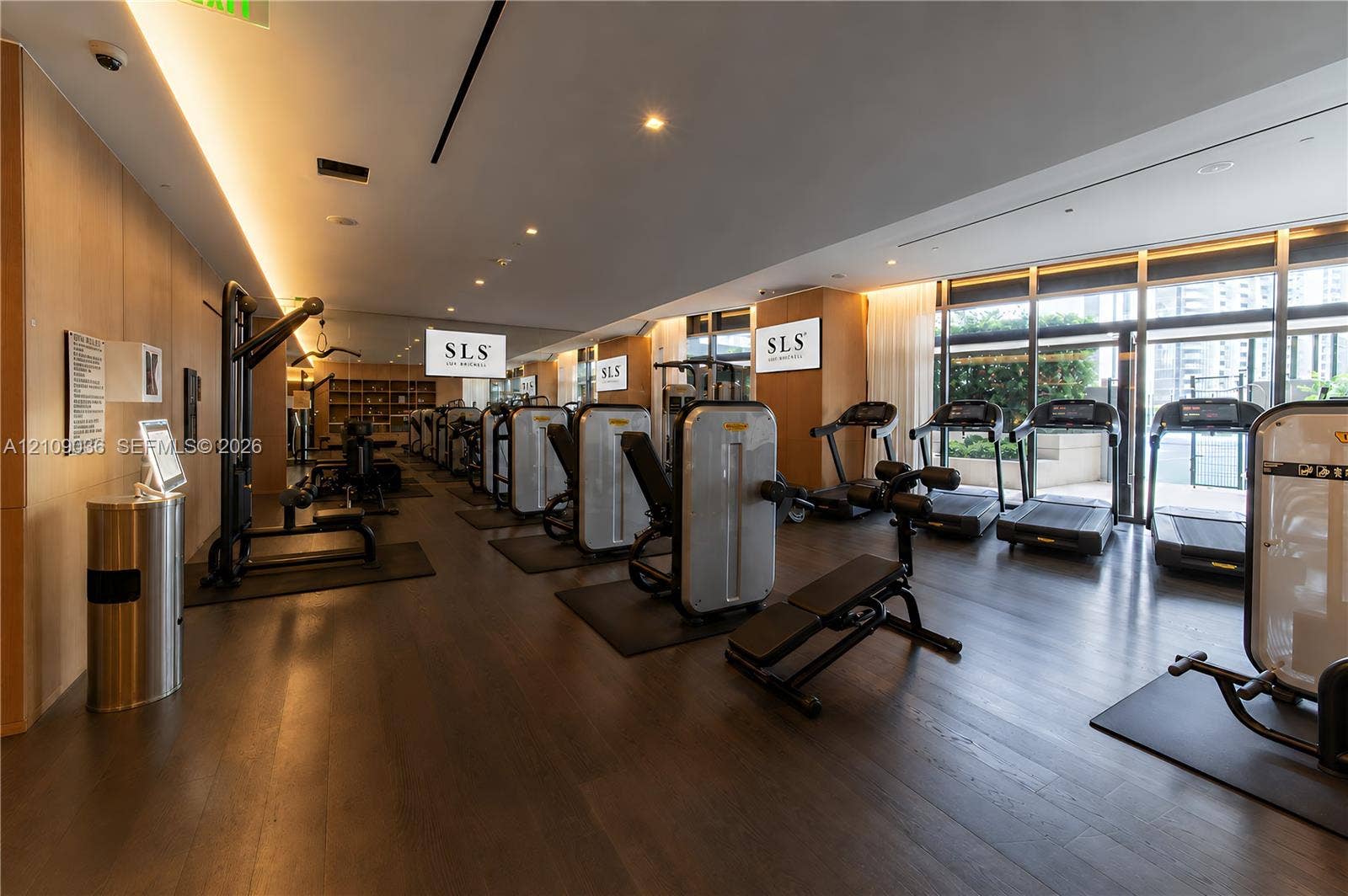 Fitness center featuring wood-finish flooring, floor-to-ceiling windows, recessed ceiling lighting, and perimeter wall-paneling