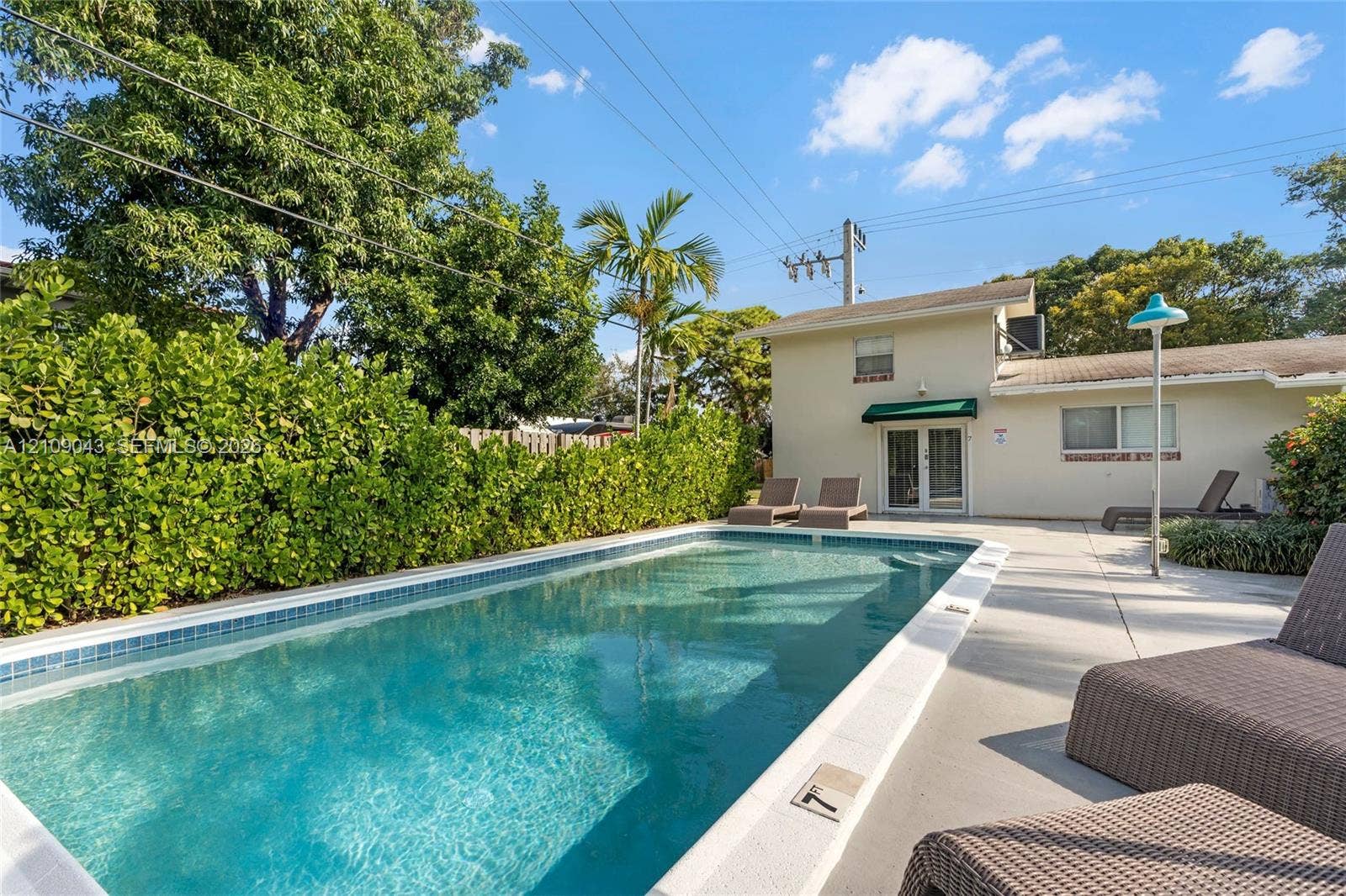 605 SW 17th Street, #1-3, Fort Lauderdale, Fort Lauderdale, FL 33315 In-ground swimming pool with a concrete surround, enclosed by mature perimeter hedging and established palm trees