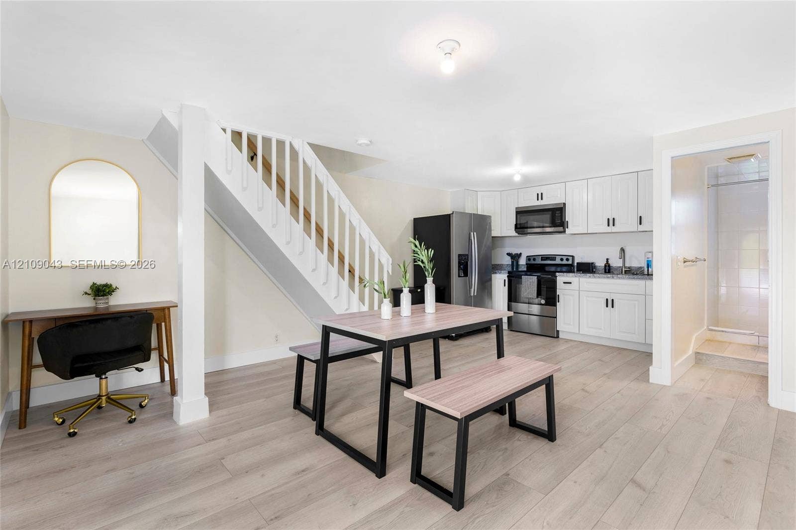 605 SW 17th Street, #1-3, Fort Lauderdale, Fort Lauderdale, FL 33315 Open-concept kitchen featuring white shaker-style cabinetry, stainless steel appliances, and wood-finish flooring, complemented by a staircase with white balusters