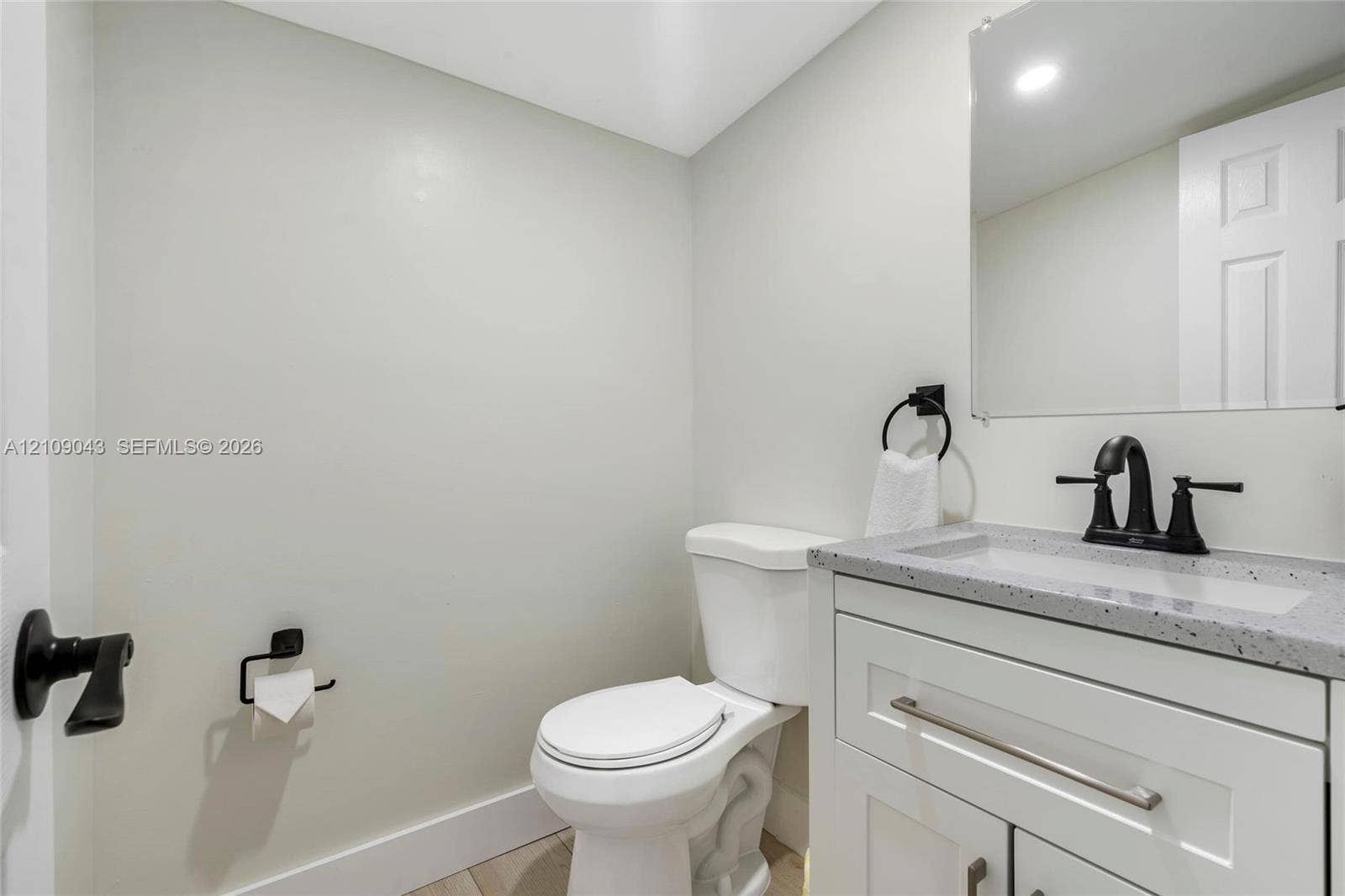 605 SW 17th Street, #1-3, Fort Lauderdale, Fort Lauderdale, FL 33315 White vanity with speckled composite countertop, undermount sink, matte black faucet, wall-mounted mirror, and matching matte black hardware