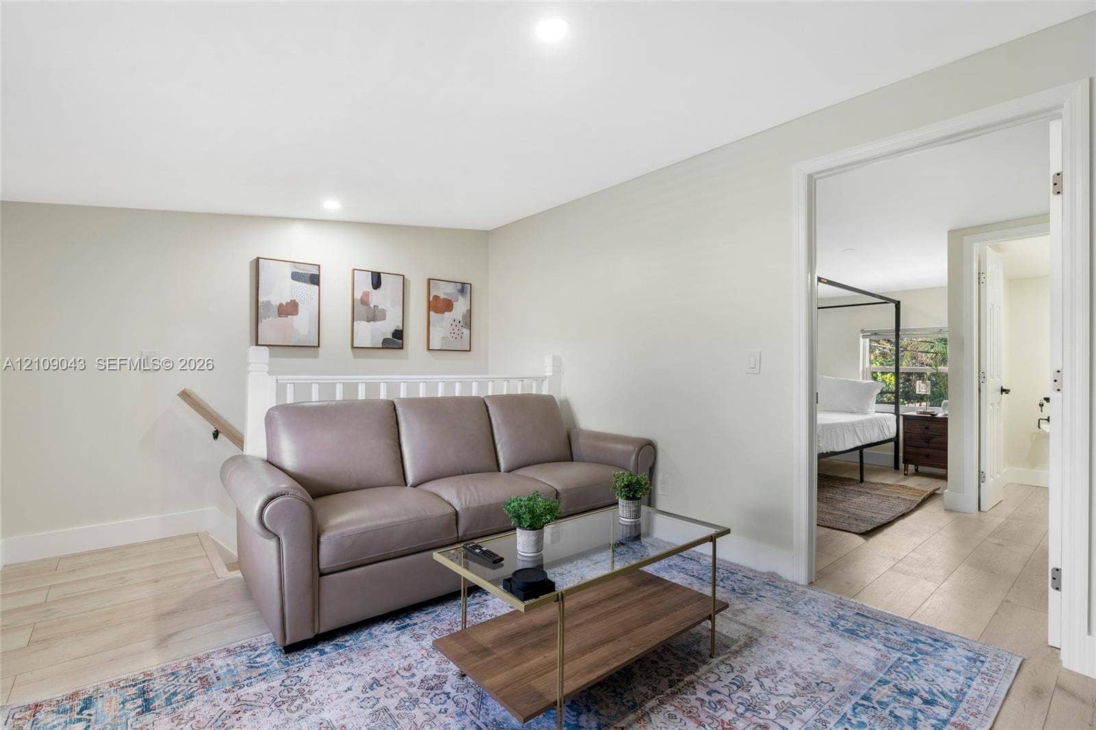 605 SW 17th Street, #1-3, Fort Lauderdale, Fort Lauderdale, FL 33315 Neutral wall paint, wood-finish flooring, and white spindle railing with a wooden handrail