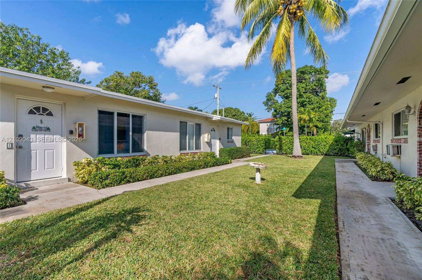 605 SW 17th Street, #1-3, Fort Lauderdale, Fort Lauderdale, FL 33315 Stucco exterior with multi-panel entry doors, concrete walkways, manicured lawn, and mature palm tree landscaping